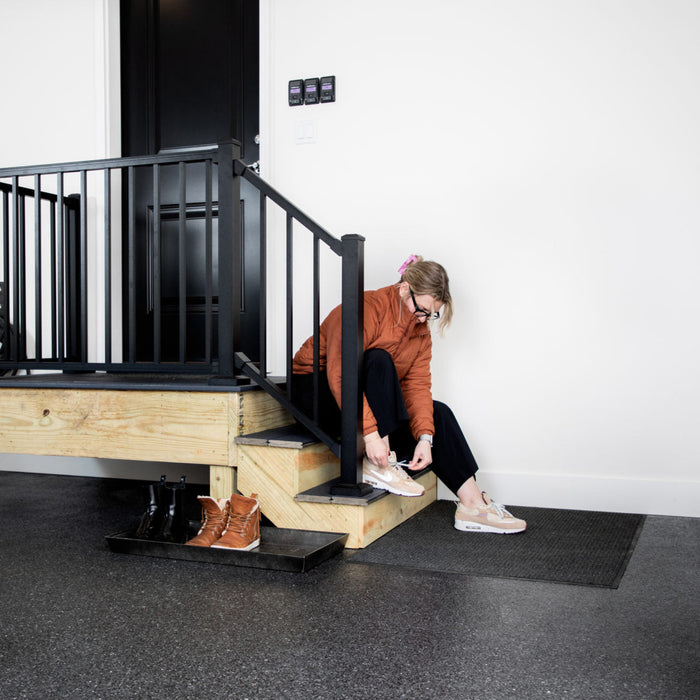 Carbon flake epoxy floor with seating area and black railing – slip-resistant matte finish.