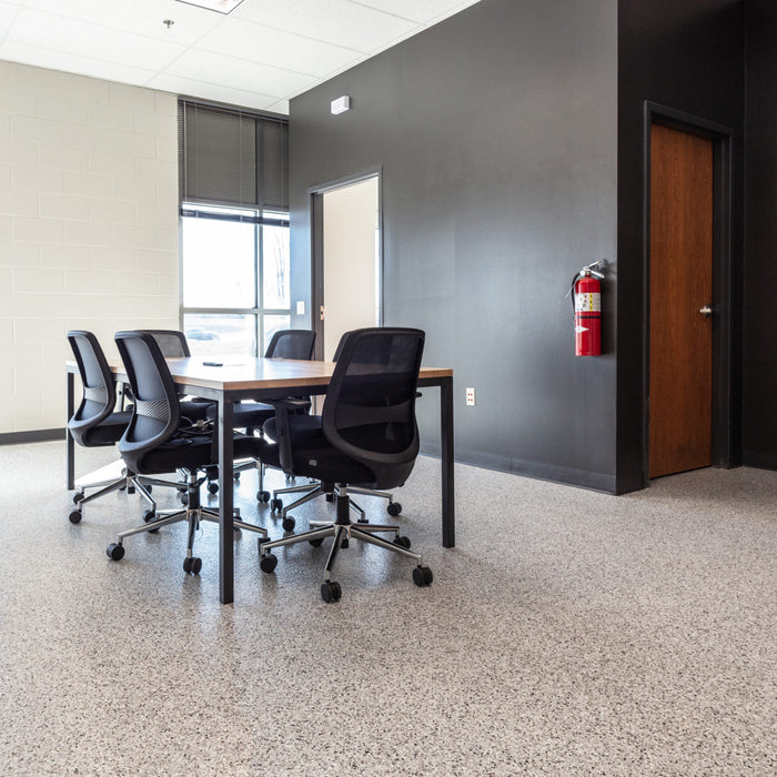 Close-up view of Coyote flake epoxy flooring under furniture – durable, textured surface finish.